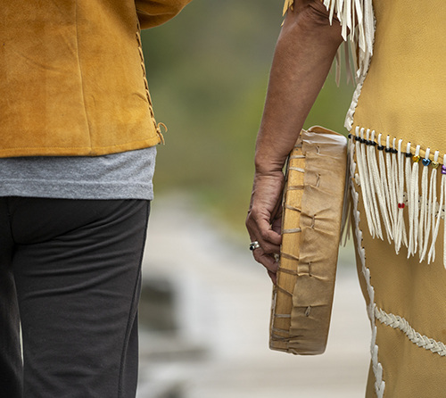 Indigenous women walk along boardwalk